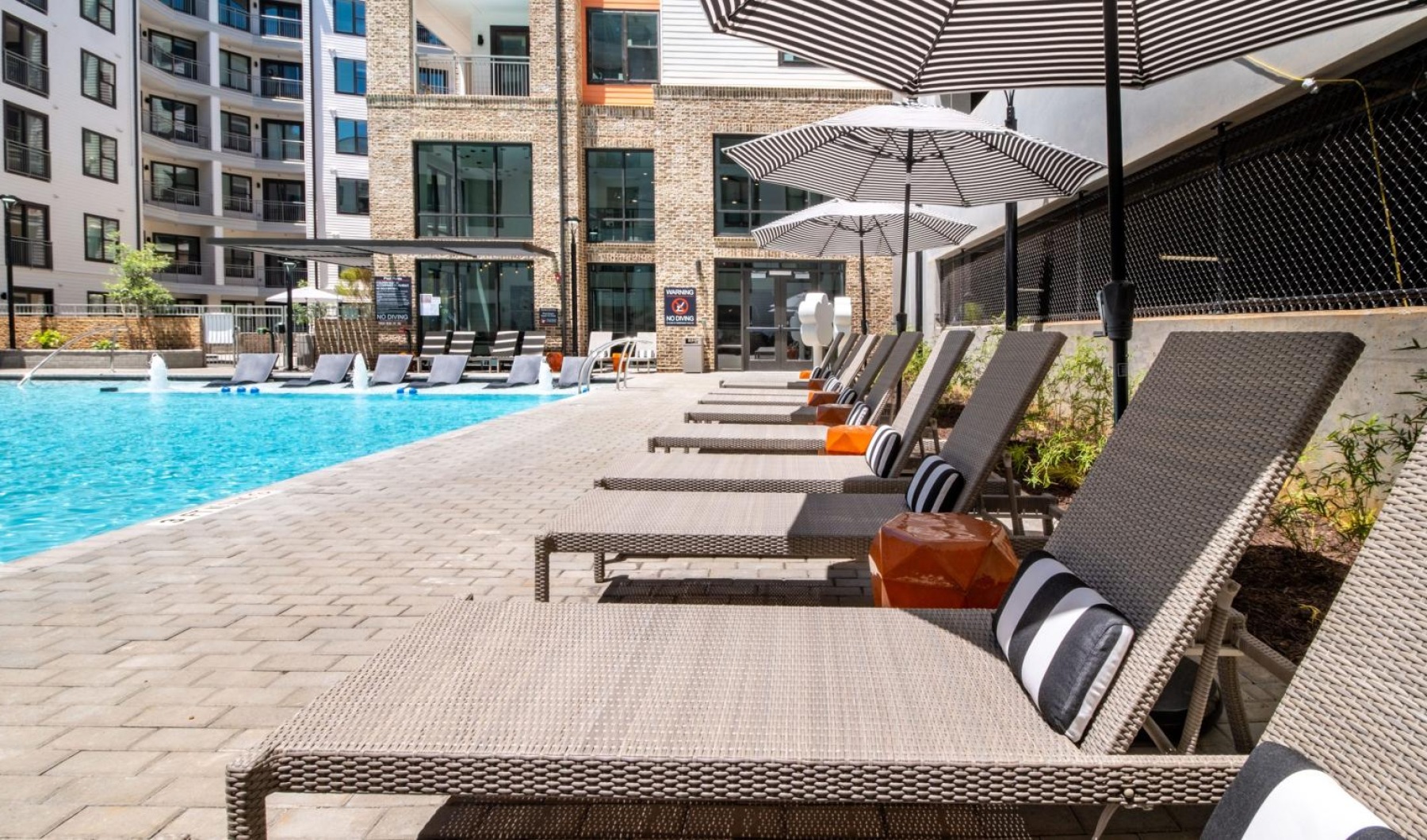 a pool with chairs and umbrellas by it